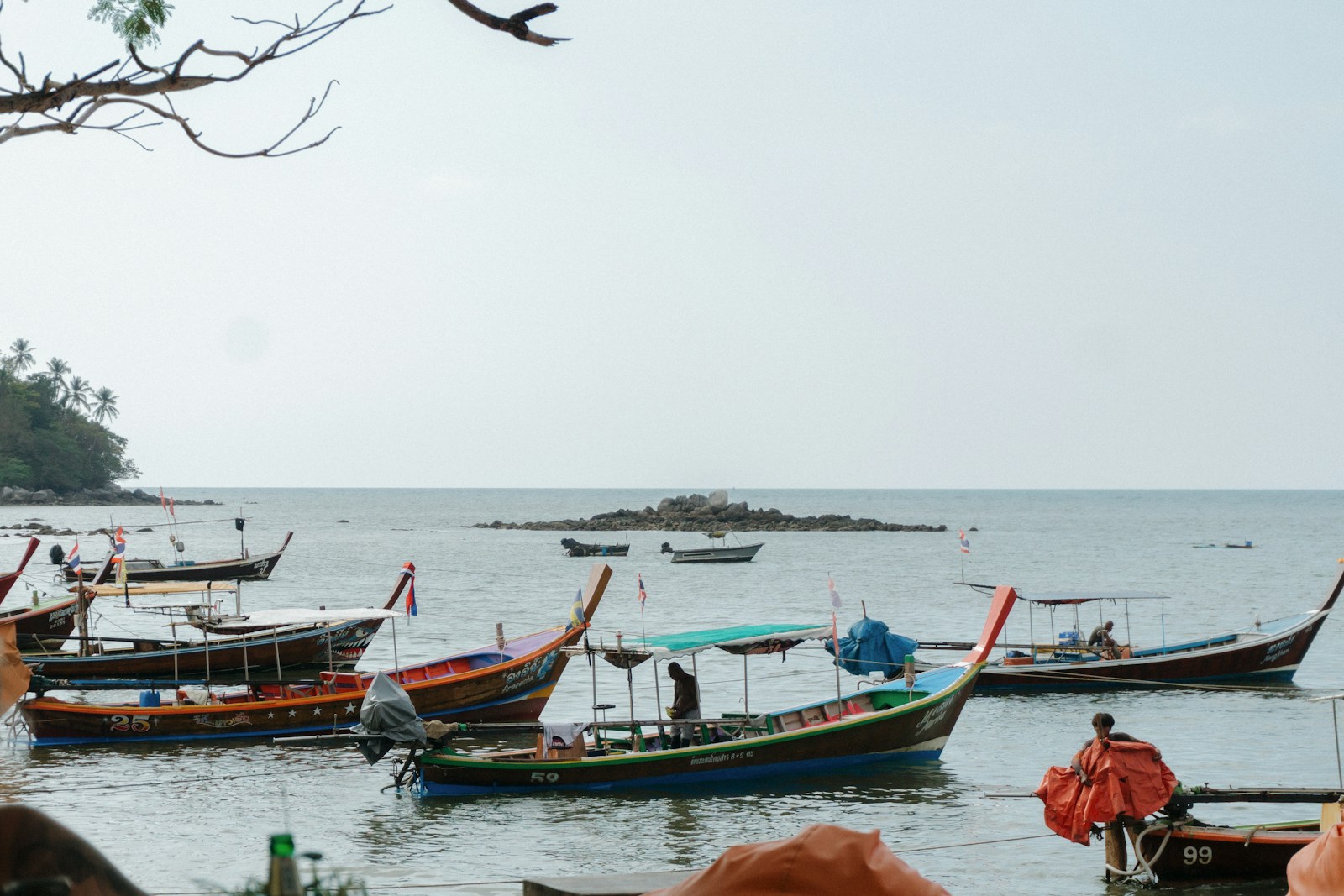 Longtail boats anchored close to a Thai shoreline